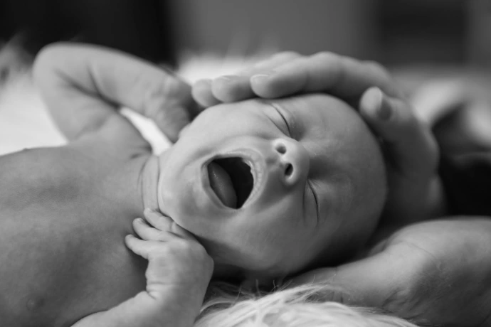 un bébé en train de pleurer que son parent calme
